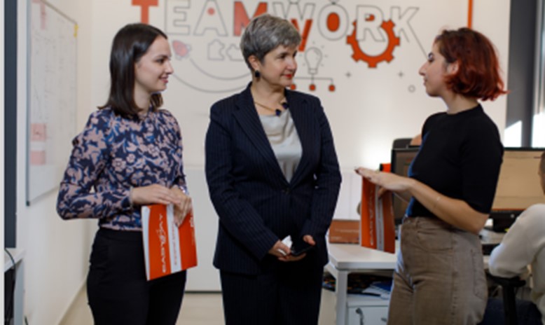 two young professionals discuss with a person in a senior position in an innovation room